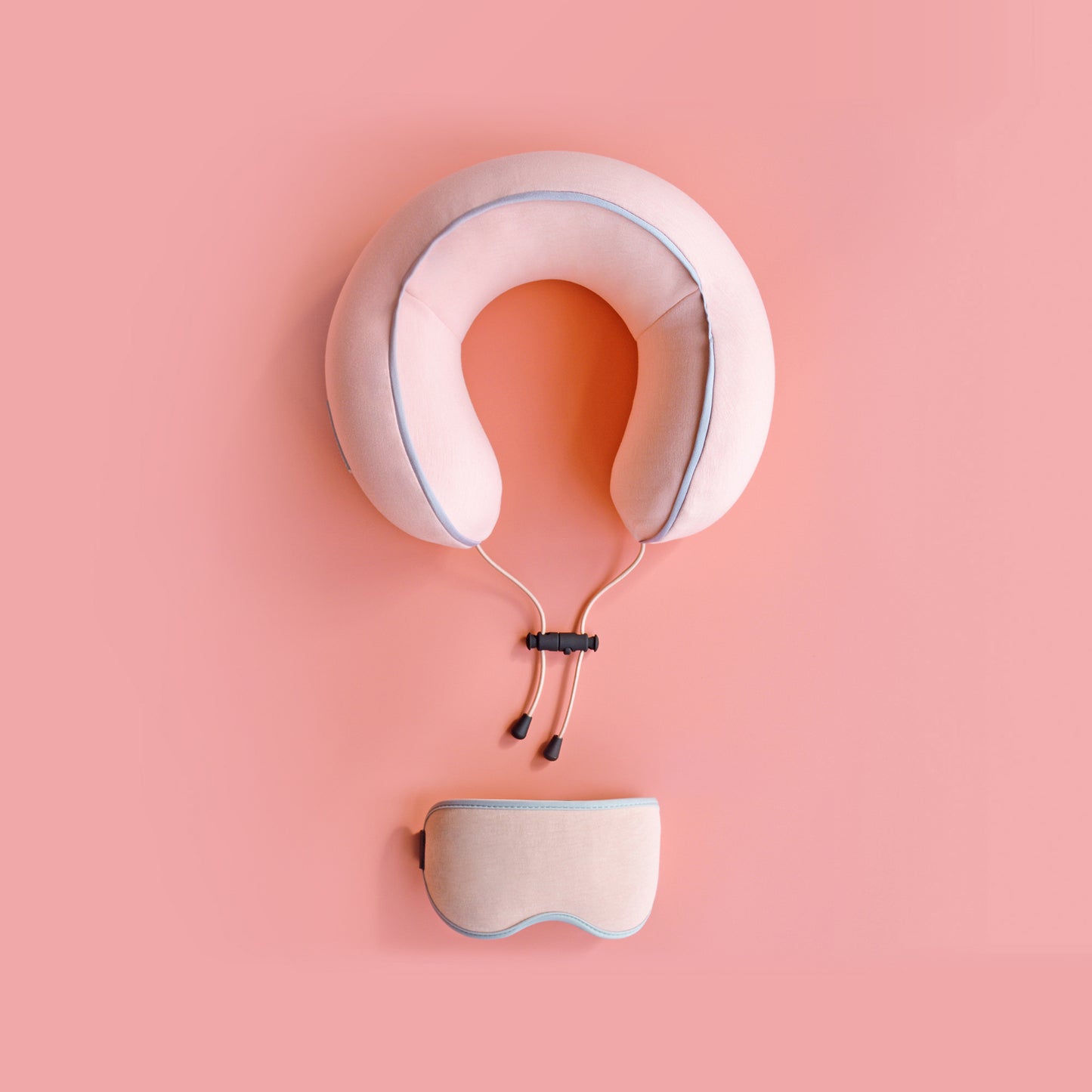 Pink Neck pillow and eye mask set on a pink background